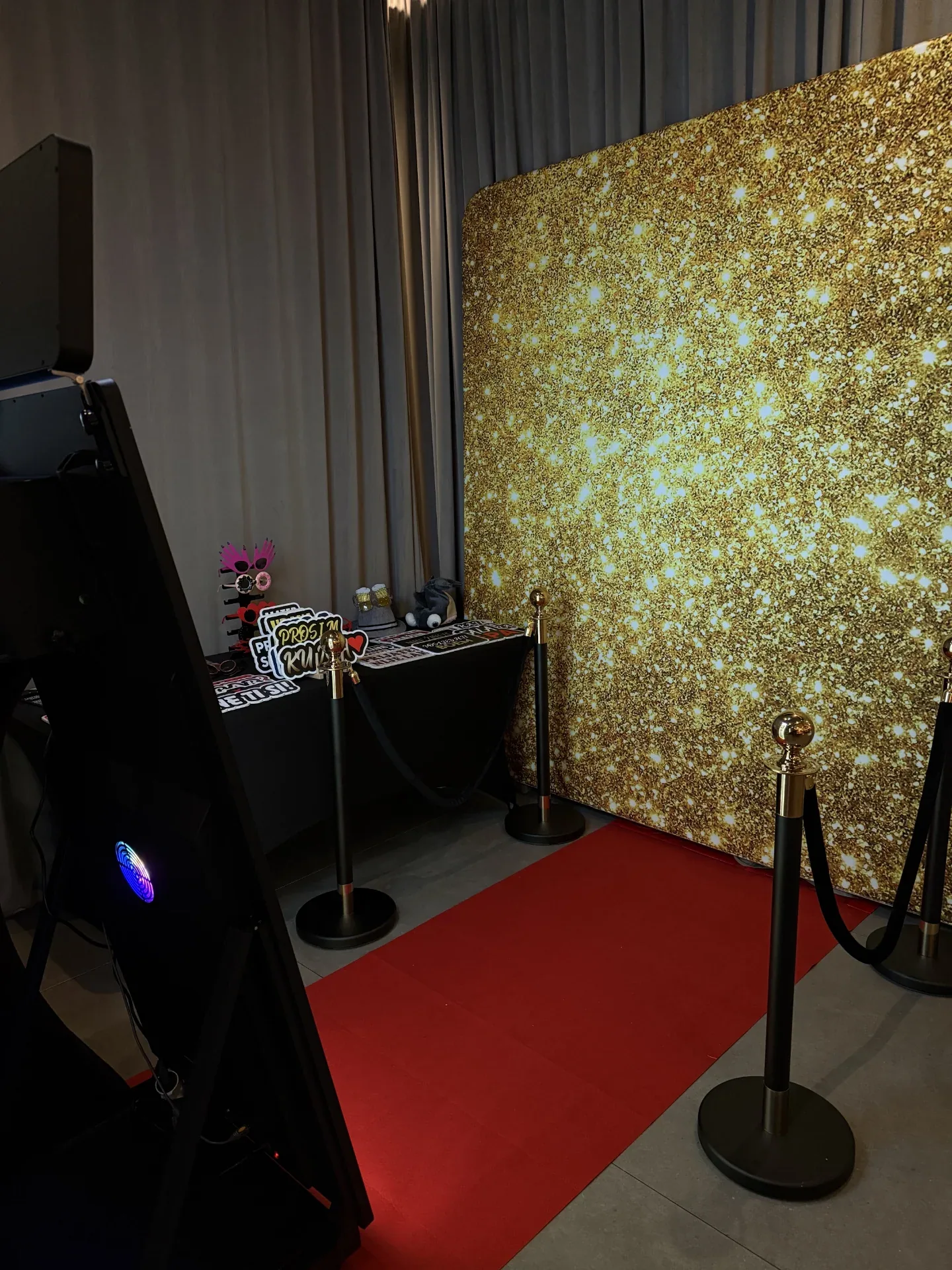 Photobooth kutak sa zlatnom svjetlucavom pozadinom i crvenim tepihom