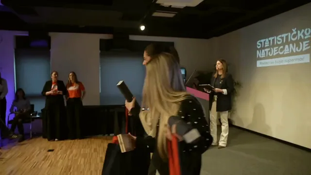 Grupna fotografija sudionika natjecanja na pozornici ispred velikog ekrana